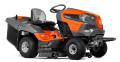 Traktor TC 238TX Husqvarna w kolorze pomarańczowym i szarym, z siedzeniem użytkownika, stojący z przodu. Posiada szerokie koła, system koszenia z tylnym pojemnikiem na trawę oraz wyraźne logo Husqvarna na obudowie. Tło jednolite.