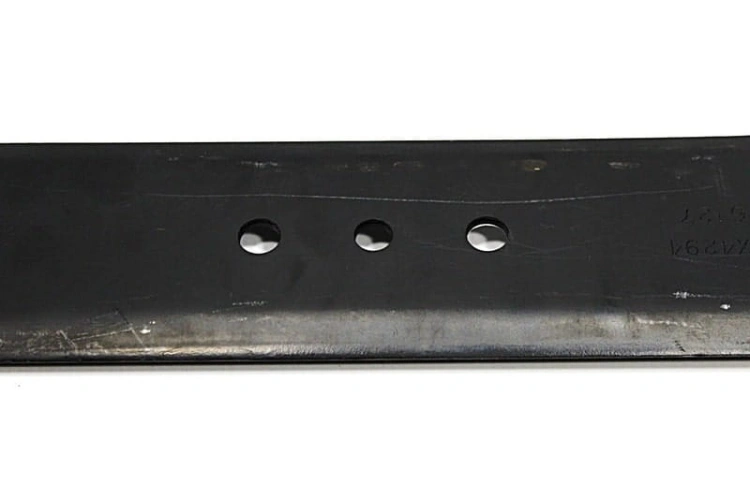 Nóż kosiarki MTD o długości 53,8 cm, wykonany z metalu, w kolorze czarnym. Ukazany z boku, w pozycji leżącej. Widać trzy otwory mocujące na końcu ostrza. Faktura matowa, z widocznymi zarysowaniami oraz napisami wzdłuż krawędzi.