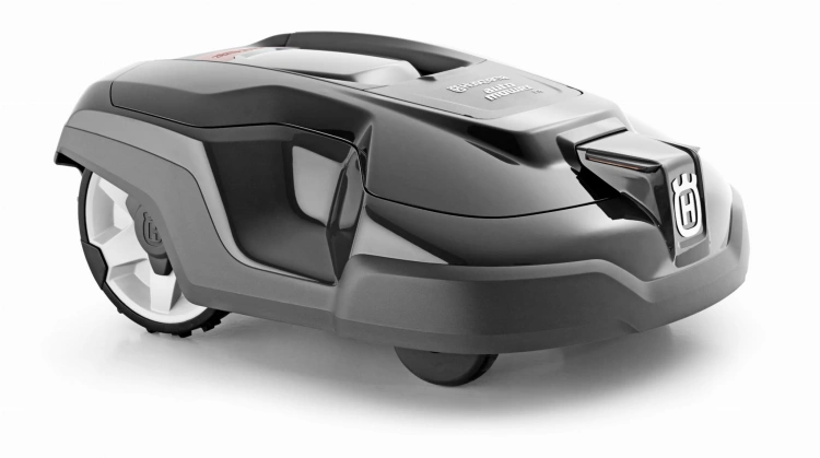 Obudowa robota koszącego Automower 310/315 w kolorze białym, pomarańczowym i grafitowym, ukazana z boku. Kształt opływowy, z wyraźnym logo. Widać jedną z kół, co podkreśla funkcjonalność. Tło jasne, co uwidacznia detale produktu.
