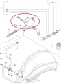 Zawór do przecinarki Husqvarna K960, widok boczny. Metalowy element z oznaczeniami i wlotem, zamocowany na krótkiej rurce, otoczony innymi częściami. Proste tło.