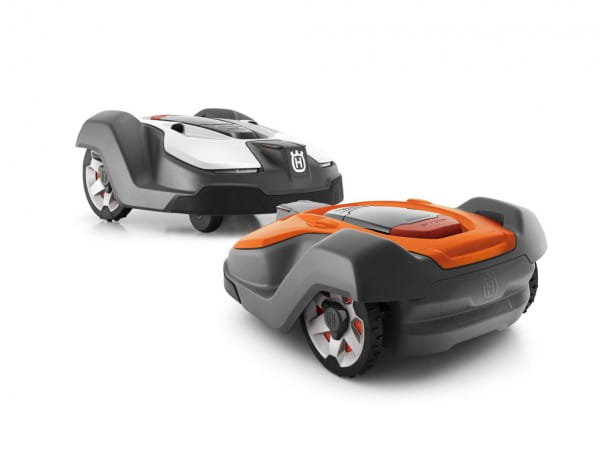 Automower® 450X to robot koszący w kolorze szaro-pomarańczowym, widoczny z przodu i z boku. Posiada aerodynamiczny kształt z logo Husqvarna na obudowie. Detale obejmują duże koła oraz wyraźny zarys pokrywy. Produkt na jednolitym tle.