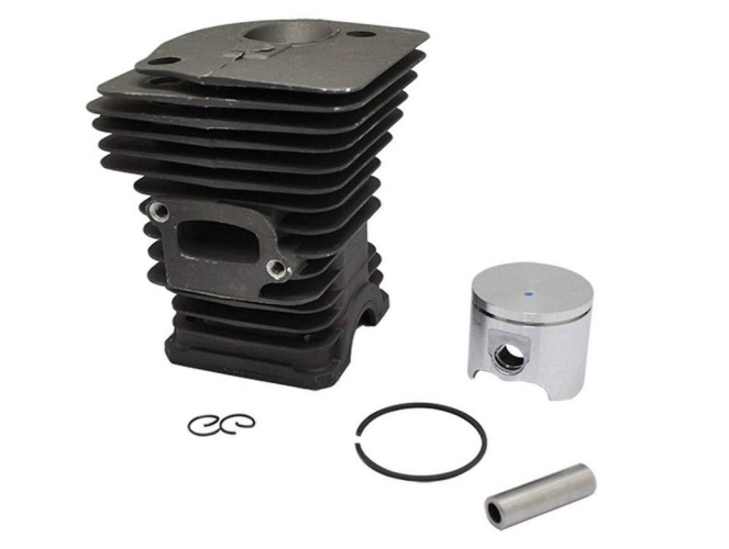 Cylinder kompletny pilarki Husqvarna 340 w kolorze czarnym z charakterystycznym żeberkowaniem na obudowie. Widoczny metalowy tłok w srebrnym kolorze obok cylindra, wraz z pierścieniem oraz elementem montażowym. Produkt leży na jasnym tle.