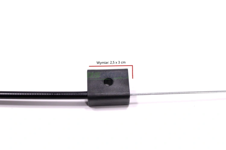 Linka hamulca do kosiarki pchanej LC348V Husqvarna z plastikowym uchwytem. Ujęcie z boku, widoczny kształt prostokątny uchwytu o wymiarach 2,5 x 3 cm. Wzdłużny kabel ze stalowym rdzeniem. Tło białe, co podkreśla detale.