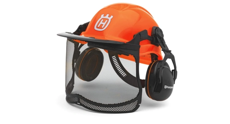 Kask leśny Functional Husqvarna w kolorze pomarańczowym, z siatkową osłoną twarzy i ochronnikami słuchu, prezentowany z przodu. Widoczne logo Husqvarna na boku kasku, do zastosowania w leśnictwie i pracach na świeżym powietrzu.