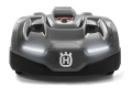 Robot koszący Husqvarna Automower 435X AWD, szaro-czarny, frontalny widok, z dwoma reflektorami LED i logo na dole, gładkie nadwozie, stoi na jednolitym tle.