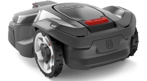 Automower® 405X robot koszący Husqvarna w kolorze ciemnoszarym z białymi felgami. Ujęcie z boku, ukazujące przycisk Stop w czerwonym kolorze. Gładka, aerodynamiczna forma z logo Husqvarna widocznym z tyłu. Produkt w pozycji leżącej.