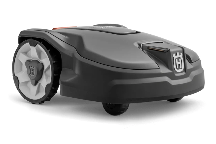 Robot koszący Husqvarna Automower® 310 Mark II w kolorze szaro-czarnym, widok z boku, na płaskiej powierzchni. Owalny kształt, z logo Husqvarna na przodzie oraz białymi, sześcioramiennymi kołami. Górna część z przyciskami do sterowania.