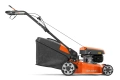 Kosiarka spalinowa LC 140SP Husqvarna w kolorze pomarańczowym i czarnym, widok z boku. Produkt z dużymi, srebrnymi kołami i siatką na trawę. Silnik umieszczony po prawej, uchwyt ergonomiczny, konstrukcja stojąca, idealna do koszenia trawnika.