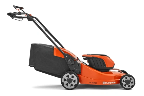 Kosiarka akumulatorowa Husqvarna LC353iVX w kolorze pomarańczowym, z czarnym koszem na trawę. Ujęcie z boku, prezentujące strukturę kół i uchwyt. Widoczna nazwa modelu na kadłubie. Produkt w pozycji stojącej, w otoczeniu z białym tłem.