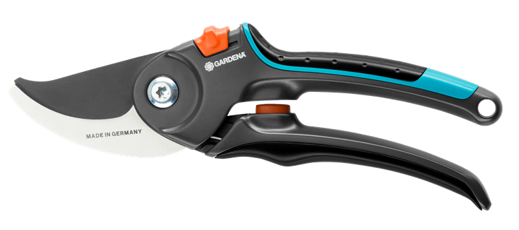 Sekator ogrodowy Gardena B/M Comfort z ostrzem o falowanej krawędzi, czarno-niebieską rączką z ergonomicznymi zapięciami, z widocznym logo na obudowie i pomarańczowym przyciskiem. Produkt ukazany w pozycji leżącej, na jednolitym tle.
