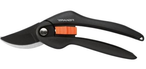 Sekator nożycowy Fiskars w kolorze czarnym z pomarańczowym mechanizmem. Ujęcie z boku. Narzędzie ma stalowe ostrze z wyprofilowanym kształtem do precyzyjnego cięcia. Obok widoczny przycisk otwierający i metalowy element mocujący. Bez tła.