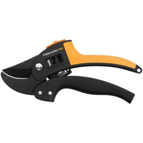 Sekator kowadełkowy PowerStep™ Fiskars z czarnymi ostrzami i pomarańczową rączką, widok z boku. Produkt z ergonomicznego tworzywa, z mechanizmem regulacji siły cięcia, oznaczenia pokazujące poziom, do ogrodnictwa. Tło proste, jasne.