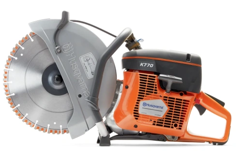 Pomarańczowo-szara spalinowa przecinarka Husqvarna K 770 z metalową, 14-calową tarczą o ząbkach w pomarańczowym kolorze, leżąca z widocznym logo i oznaczeniem modelu na obudowie.
