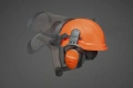 Pomarańczowy kask Functional Husqvarna z radiem FM, regulowanym nausznikiem z logo, solidnym daszkiem i osłoną twarzy, pokazany z boku na szarym tle, ukazujący detale i system mocowania.