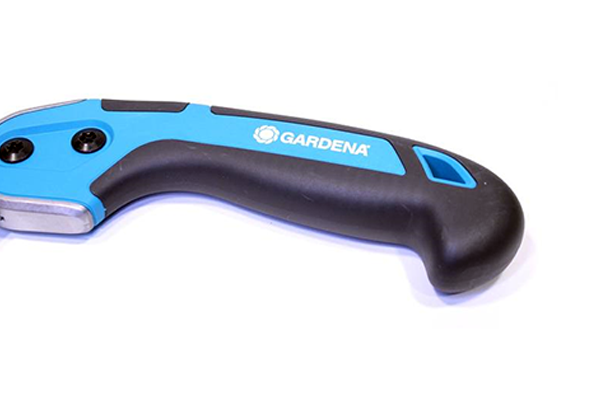 Ergonomiczny uchwyt piły ogrodowej 300P GARDENA w kolorze błękitnym z czarnymi akcentami. Widok z boku, uchwyt lekko zakrzywiony dla komfortu użytkowania. Wyraźne logo GARDENA nadrukowane na uchwycie. Trwały materiał oraz solidne mocowanie ostrza.
