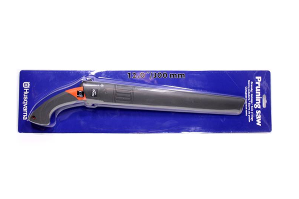 Piła ręczna 300 mm z ergonomiczną, szaro-pomarańczową rączką oraz osłoną, umieszczona na niebieskiej kartonowej etykiecie. Produkt leży na płasko, a jego ostrze ma matową fakturę. Logo Husqvarna jest widoczne na opakowaniu.