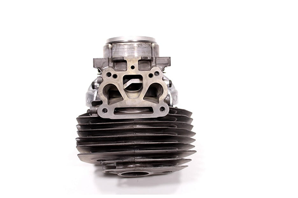 Cylinder do pilarki Husqvarna 560XP/562XP, front. Metalowy, dużej średnicy, z nierdzewnymi żeberkami chłodzącymi. Górny element z okrągłym tłokiem i otworami montażowymi. Solidne mocowanie od dołu.