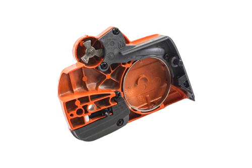 Zespół hamulca/pokrywa sprzęgła pilarki Husqvarna 435, 135, 140, 440 II w kolorze pomarańczowym i szarym. Produkt widoczny z boku, w pozycji leżącej, z detalami mechanicznymi i otworem na śrubę. Nieczytelne napisy na obudowie.