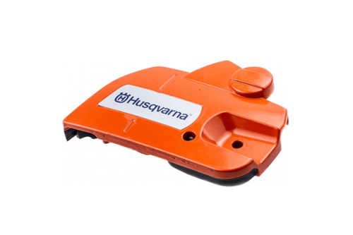 Zespół hamulca pilarki Husqvarna, w kolorze pomarańczowym, wykonany z plastiku. Ujęcie z boku, produkt leży na płaskiej powierzchni. Widoczne logo Husqvarna oraz przycisk blokady. Element o gładkiej fakturze, przeznaczony do pilarki 450.