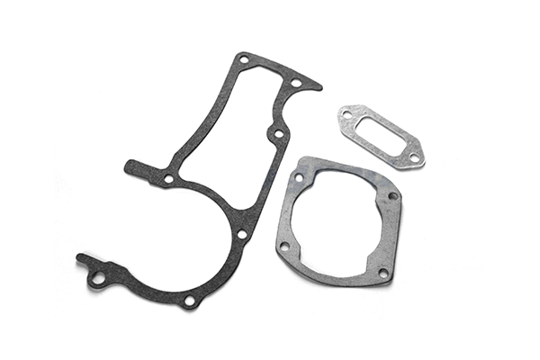 Zestaw uszczelek do pilarek Husqvarna 362/365/372XP, różne kształty i rozmiary, szare i czarne, leżą na białym tle. Widać detale krawędzi i wycięcia.