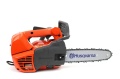 Pilarka Husqvarna T525 w kolorze pomarańczowym z szarymi elementami, widoczna z boku, z wyeksponowanym łańcuchem na stalowej prowadnicy z logo Husqvarna. Ergonomiczny uchwyt, duża osłona, przeznaczona do precyzyjnego cięcia w ogrodzie.