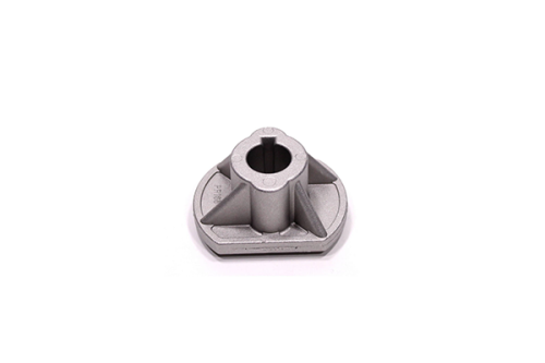 Adapter noża piasty kosiarki o średnicy 20 mm, w kolorze szarym. W widoku z góry, leżący. Owalny kształt z wypustkami oraz centralnym otworem. Wykonany z metalu, z widocznymi detalami strukturalnymi. Na jednolitym tle.