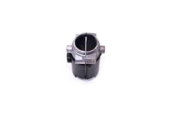 Tuleja kosy 323R Husqvarna w kolorze czarnym, wykonana z metalu. Zbliżenie na element z otworem w kształcie cylindra, umieszczony w centralnej części. Widoczne mocowanie oraz szczelina wzdłużna. Produkt leży na białym tle.