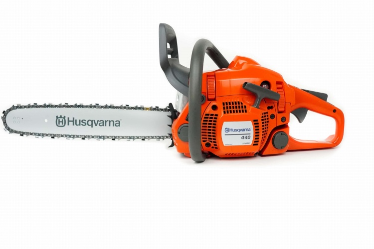 Pilarka Husqvarna 440 w kolorze pomarańczowym, z metalowym łańcuchem i prowadnicą, widoczna z boku. Wyposażona w uchwyt i kontrolki, zapewniająca ergonomiczną obsługę. Tło białe, co podkreśla detale produktu.
