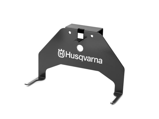 Wieszak na kosiarkę Automower Husqvarna 305/415X w kolorze czarnym, wykonany z metalu. Ujęcie frontalne, produkt zamontowany, z czytelnym logo Husqvarna na froncie. Elementy mocujące widoczne po bokach, prosta struktura. Tło jednolite.