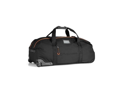Torba turystyczna Xplorer 90L Husqvarna, czarna z pomarańczowymi detalami, z boku, na kółkach, z dwoma rączkami, zamkiem błyskawicznym oraz logo. Materiał tekstylny, prosty kształt, idealna do podróży.