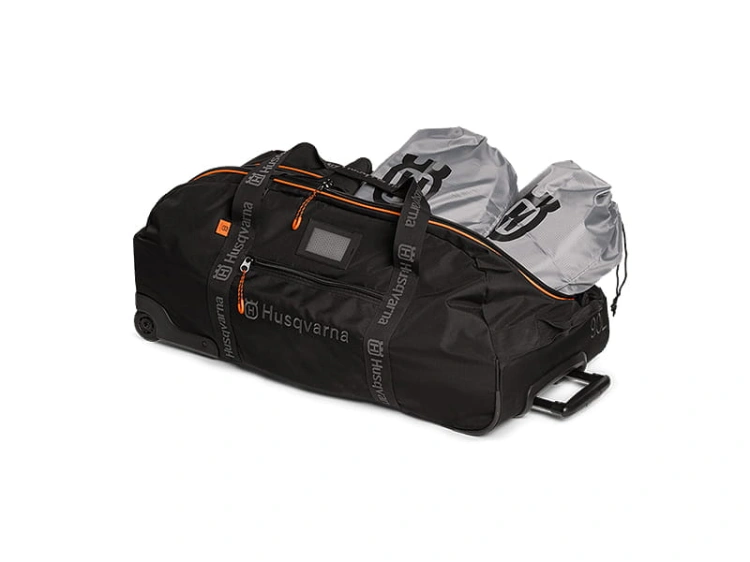 Torba turystyczna Husqvarna Xplorer 90L czarna z pomarańczowymi detalami, logo i zamkami. W zestawie 2 szare torby, kółka i rączka na prostym tle podkreślającym detale.