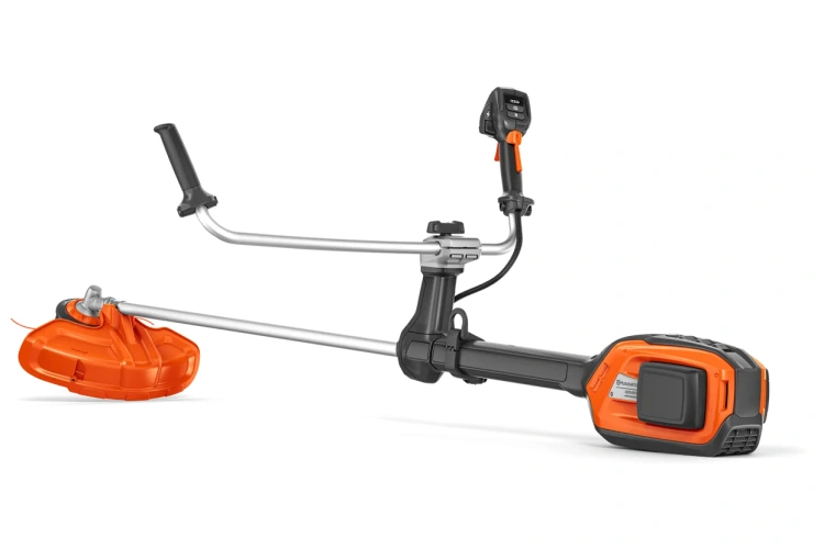 Wykaszarka akumulatorowa Husqvarna 525iRXT z metalowym ramieniem i ergonomiczną rączką, w kolorze pomarańczowym. Ujęcie frontalne, produkt rozłożony, z widocznym akumulatorem. Ostrze tnące w kształcie półokręgu na końcu roboczym.