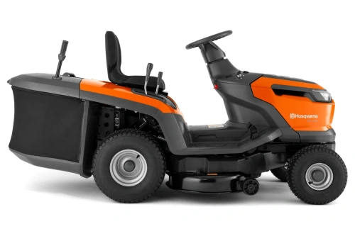 Traktor Husqvarna TC112 w kolorze pomarańczowym i szarym, z siedziskiem, kierownicą oraz dwa lewymi uchwytami. Ujęcie z boku, pokazujące położenie kół oraz strefę cięcia. Widać także logo Husqvarna na obudowie. Silnik umieszczony z tyłu.