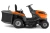 Traktor Husqvarna TC112 w kolorze pomarańczowym i szarym, z siedziskiem, kierownicą oraz dwa lewymi uchwytami. Ujęcie z boku, pokazujące położenie kół oraz strefę cięcia. Widać także logo Husqvarna na obudowie. Silnik umieszczony z tyłu.
