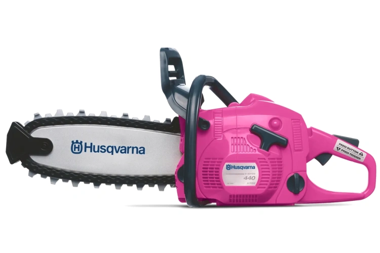 Zabawka pilarka Husqvarna 440 limitowana, różowa z czarnymi elementami, frontalne ujęcie, logo na obudowie i prowadnicy, przyciski i dźwignie do zabawy, neutralne tło.