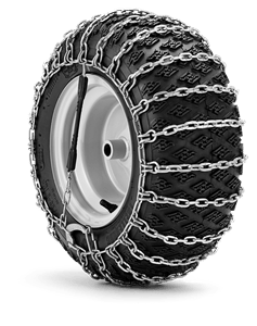 Łańcuchy śniegowe 16x6-8 do riderów Husqvarna na czarnej oponie z białą obręczą, w zbliżeniu pokazujące metalową siatkową konstrukcję, ułożone na jednolitym tle.