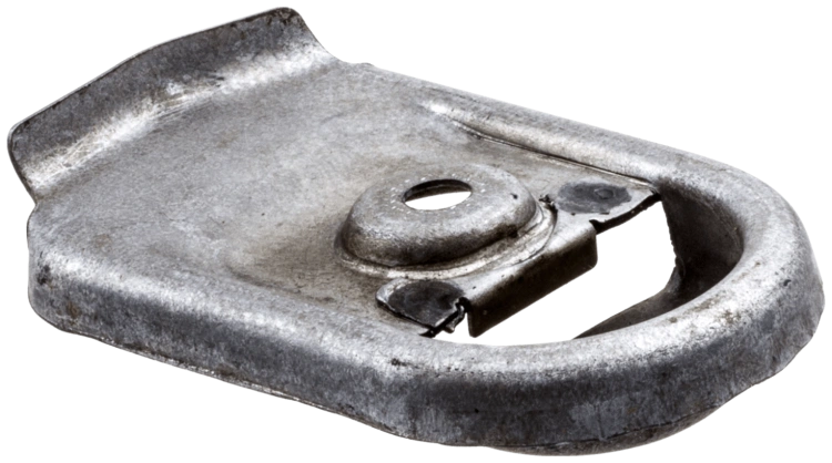 Płytka tłumika pilarki w kolorze metalicznym, o prostokątnym kształcie z wycięciem na mocowanie. Widoczny otwór w centralnej części oraz wygięte brzegi. Ujęcie z boku, leżący na płaskiej powierzchni, z detalami struktury powierzchni.