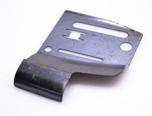 Osłona karteru do pilarki Husqvarna 254, 262XP w kolorze stalowym. Widok z boku, produkt rozłożony, z wyraźnymi otworami montażowymi i rowkami. Powierzchnia ma fakturę matową, z widocznymi zadrapaniami.