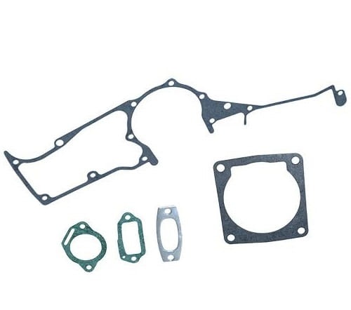 Zestaw 5 uszczelek do pilarki Husqvarna 3120, w różnych kształtach, cienkie, zielone, gładkie, układają się na białym tle. Zawierają okrągły detal i otwory montażowe.