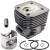 Zespół cylindra pilarki Husqvarna 3120XP: szary aluminiowy cylinder z żeberkami chłodzącymi, srebrny tłok, pierścienie tłokowe i mosiężna tuleja na białym tle.