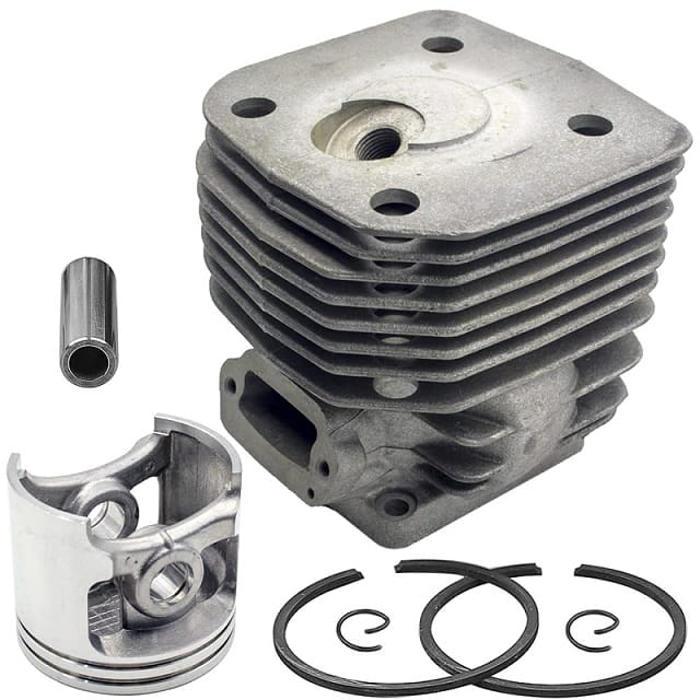 Zespół cylindra pilarki Husqvarna 3120XP: szary aluminiowy cylinder z żeberkami chłodzącymi, srebrny tłok, pierścienie tłokowe i mosiężna tuleja na białym tle.