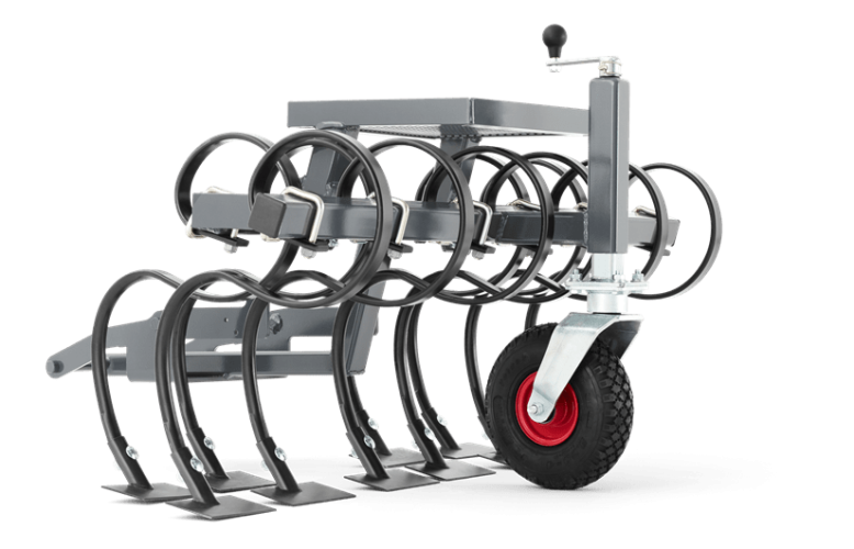 Brona do riderów Husqvarna, szara, z czterema metalowymi zębami w kształcie U, na solidnej podstawie z czerwonym kółkiem. Posiada boczny uchwyt do regulacji wysokości i montażu na urządzeniu.