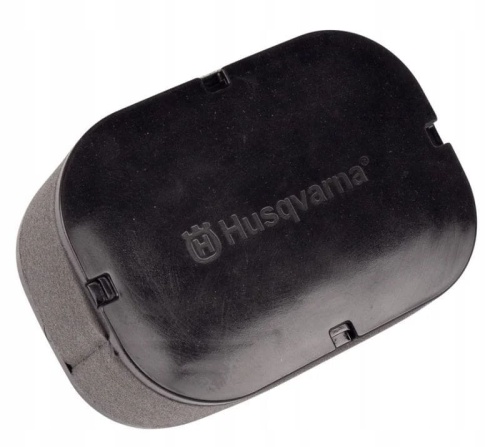 Filtr powietrza HV586AE Husqvarna w kształcie owalnym, czarny z widocznym logo Husqvarna. Produkt leży na jednolitym tle, z zamkniętą konstrukcją. W obrębie bocznych krawędzi widoczne zatrzaski do mocowania. Gładka faktura materiału.