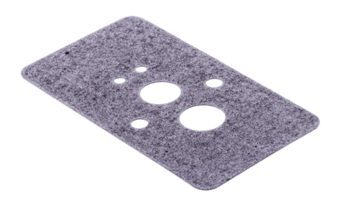 Uszczelka gaźnika dmuchawy 170BT/370BTS Husqvarna w formie prostokątnej, szarej, wykonana z tworzywa. Widoczne otwory o różnych średnicach. Produkt leży na płaskiej powierzchni, gładka faktura. Idealna do montażu w urządzeniach ogrodniczych.