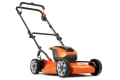 Kosiarka akumulatorowa LB144i Husqvarna w kolorze pomarańczowym i czarnym, widoczna z boku. Produkt ma składany uchwyt, solidne koła i wyprofilowany korpus. Brak akumulatora i ładowarki. Tło jednolite.