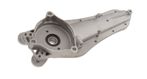 Metaliczna obudowa przekładni nożyc Husqvarna, srebrna, z gładką powierzchnią. Widoczny owalny i okrągły otwór z uszczelką. Element montażowy do urządzeń ogrodowych.