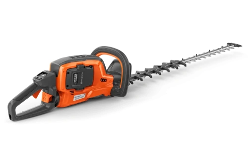 Nożyce akumulatorowe Husqvarna 522iHDR60, pomarańczowo-szare, z długim, srebrnym, ząbkowanym ostrzem, logo Husqvarna i ergonomicznym uchwytem z przyciskiem, leżące na czarnym tle.