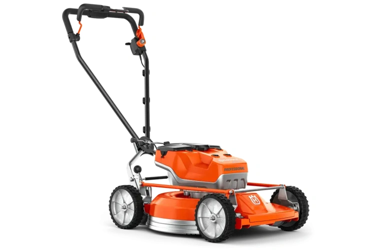 Kosiarka akumulatorowa Husqvarna LB 553iV w pomarańczowym kolorze, z metalową obudową i dużymi, gumowymi kołami. Ujęcie z boku, kosiarka stoi na ziemi, widoczne uchwyty do prowadzenia i logo Husqvarna. Stworzona do użytku profesjonalnego.