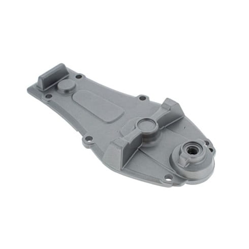 Obudowa przekładni nożyc 322HD60/522HD60S Husqvarna w kolorze szarym, wykonana z tworzywa sztucznego. Przedmiot leży na płaskiej powierzchni, ukazując detale mocowania oraz gładką teksturę. Widoczna jest pokrywa z otworem na śrubę.