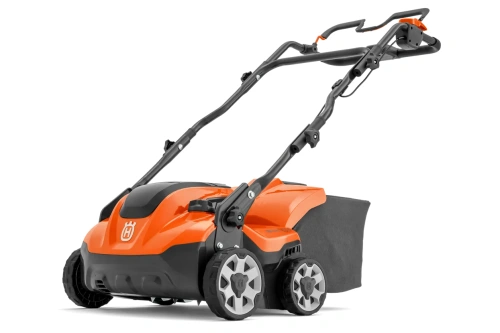 Wertykulator akumulatorowy Husqvarna S138i, pomarańczowo-czarny, z dużą teksturowaną rączką i dwoma szarymi kołami. Zestaw zawiera siatkę na trawę. Nowoczesny, prosty design do pielęgnacji trawnika.
